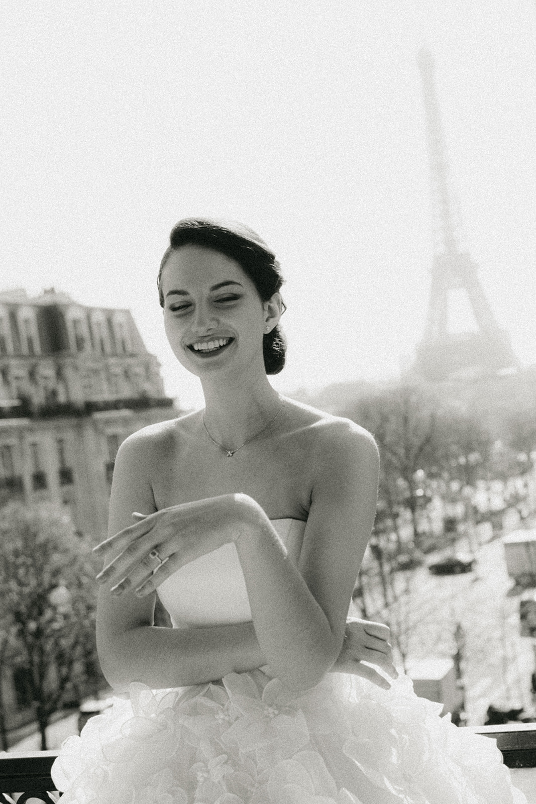Editorial bride smiling with Eiffel Tower view from Hôtel Plaza Athénée Paris